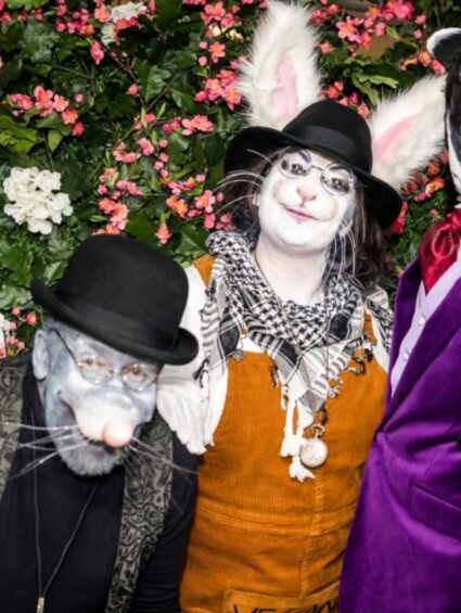 Artificial pink blossom and white flowers for hire, behind three people in mouse, rabbit and badger costumes