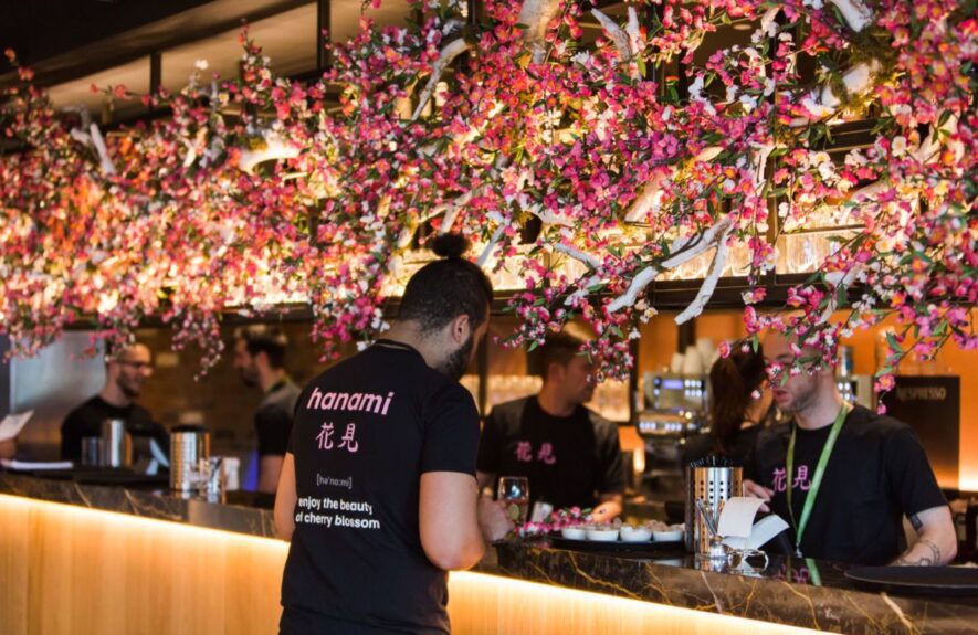 Pink artificial cherry blossom for hire, installed above a restaurant bar, staff in 'hanami' shirts