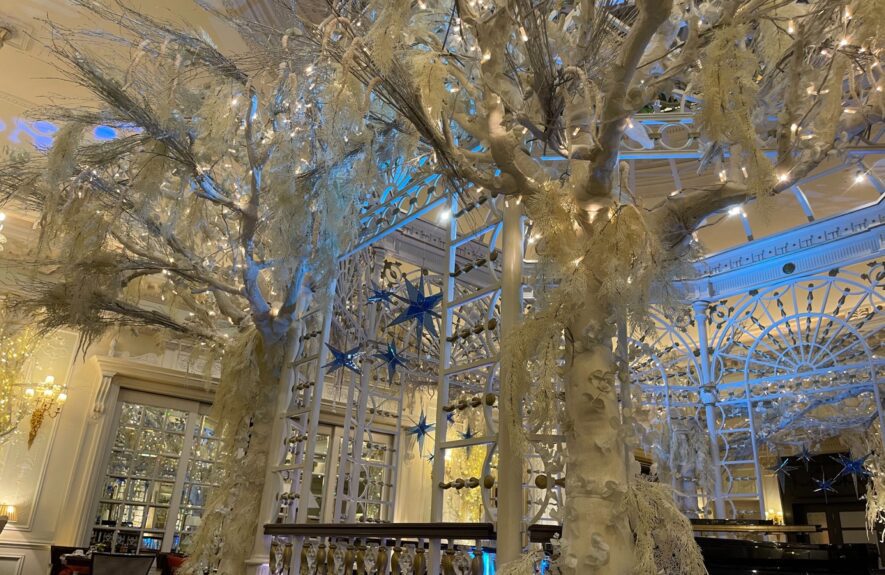 White frosted artificial trees for hire, beside a white gazebo with blue stars in the Savoy Hotel lounge