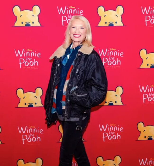 Woman posing in front of a red Winnie the Pooh backdrop at the press event