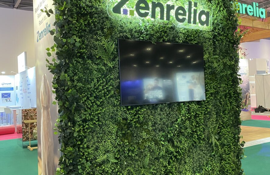 Artificial foliage wall for hire, with a lit 'Zenrelia' logo and video screen, on an exhibition stand at the London Vet Show